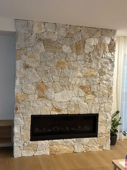 Full-height stone fireplace wall by DM Stonemasonry